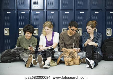 Picture - High school students hanging out, sitting on floor by lockers. Fotosearch