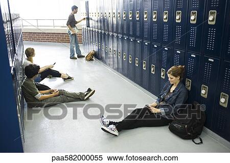 High school students sitting on floor by lockers using cell phones View Large Photo Image Stock Photography - High school students sitting on floor by lockers using cell phones. Fotosearch