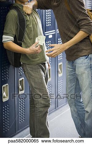 Stock Photography - Teenage boy bullying classmate and stealing his money. Fotosearch