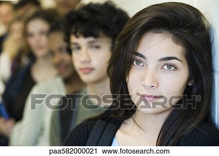 Stock Image - Teenage girl waiting at front of line, portrait. Fotosearch
