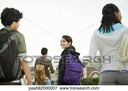 Stock Photo - Teenage girl walking with classmates. Fotosearch