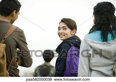 Stock Photo - Teenage girl walking with friends. Fotosearch