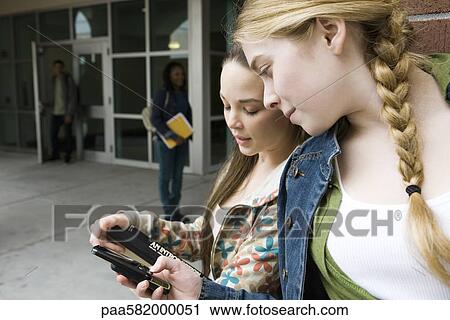 Young woman showing friend cell phone View Large Photo Image Stock Image - Young woman showing friend cell phone. Fotosearch