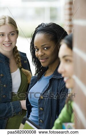 Stock Photo - Young woman with friends, portrait. Fotosearch