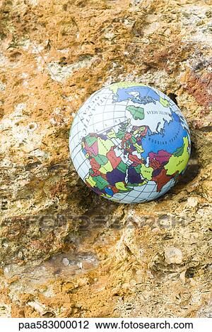 Globe nestled in rock View Large Photo Image Stock Image - Globe nestled in rock. Fotosearch