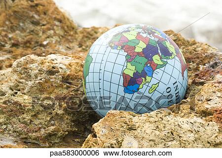 Globe nestled in rock View Large Photo Image Stock Photograph - Globe nestled in rock. Fotosearch