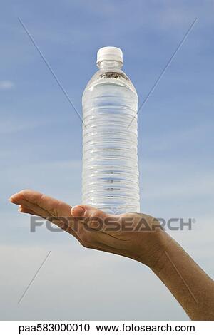 Hand holding bottle of water View Large Photo Image Stock Image - Hand holding bottle of water. Fotosearch