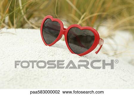 Heart-shaped sunglasses on beach View Large Photo Image Stock Image - Heart-shaped sunglasses on beach. Fotosearch