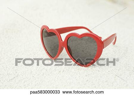 Heart-shaped sunglasses on beach View Large Photo Image Stock Image - Heart-shaped sunglasses on beach. Fotosearch