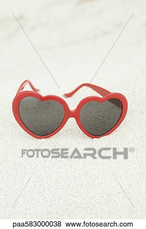 Heart-shaped sunglasses on beach View Large Photo Image Stock Photo - Heart-shaped sunglasses on beach. Fotosearch