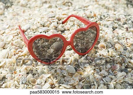 Stock Photography - Heart-shaped sunglasses on beach. Fotosearch