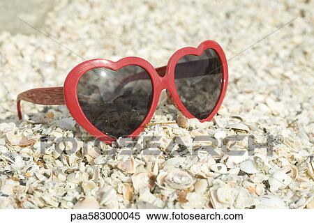 Stock Photography - Heart-shaped sunglasses on beach. Fotosearch