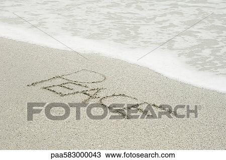 Stock Image - The word "peace" written in the sand at the beach. Fotosearch