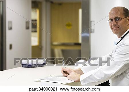 Doctor completing paperwork, portrait View Large Photo Image Stock Image - Doctor completing paperwork, portrait. Fotosearch