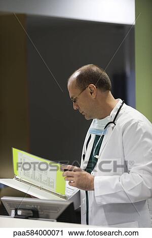 Doctor reviewing medical chart View Large Photo Image Stock Image - Doctor reviewing medical chart. Fotosearch