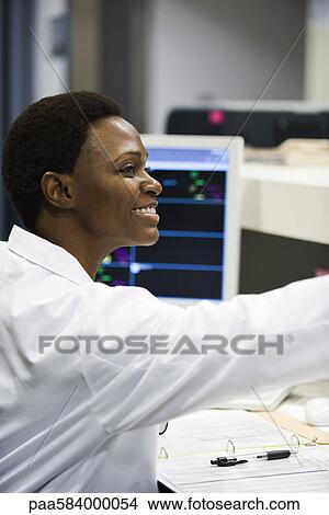 Healthcare worker at work at nurse's station View Large Photo Image Picture - Healthcare worker at work at nurse's station. Fotosearch