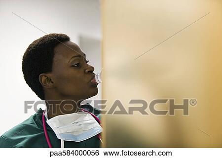 Healthcare worker drinking bottle of water View Large Photo Image Stock Photograph - Healthcare worker drinking bottle of water. Fotosearch