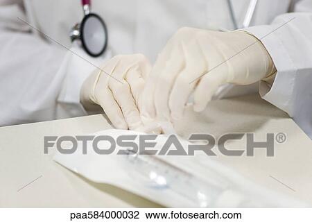 Healthcare worker opening sterile package containing medical supplies View Large Photo Image Stock Image - Healthcare worker opening sterile package containing medical supplies. Fotosearch