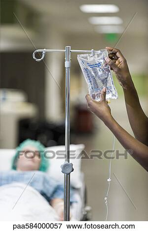 Healthcare worker preparing patient's IV drip View Large Photo Image Stock Photo - Healthcare worker preparing patient's IV drip. Fotosearch