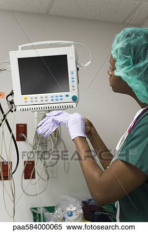Nurse checking medical equipment monitor View Large Photo Image Stock Photography - Nurse checking medical equipment monitor. Fotosearch