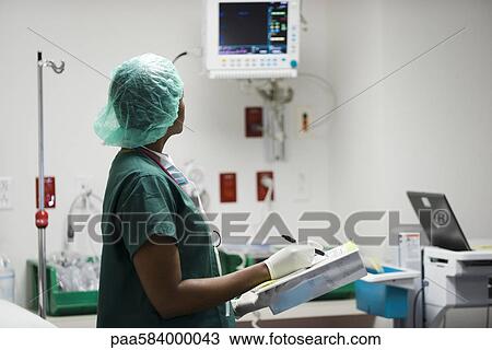 Nurse checking medical equipment monitor, recording data in medical chart View Large Photo Image Stock Image - Nurse checking medical equipment monitor, recording data in medical chart. Fotosearch