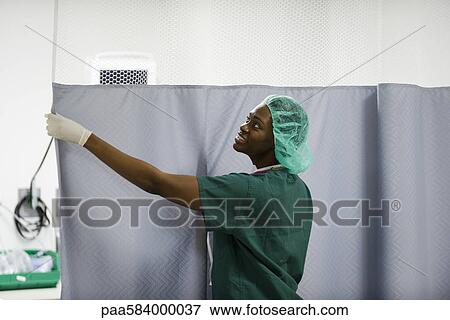 Nurse closing privacy curtain in hospital room View Large Photo Image Stock Photo - Nurse closing privacy curtain in hospital room. Fotosearch