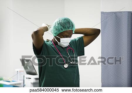Nurse putting on surgical mask View Large Photo Image Stock Photography - Nurse putting on surgical mask. Fotosearch