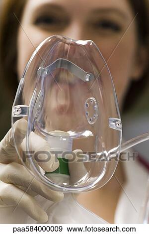 Stock Photo - Putting oxygen mask on patient, personal perspective. Fotosearch