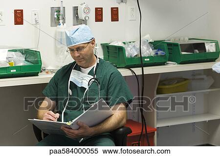 Stock Photography - Surgeon completing paperwork. Fotosearch