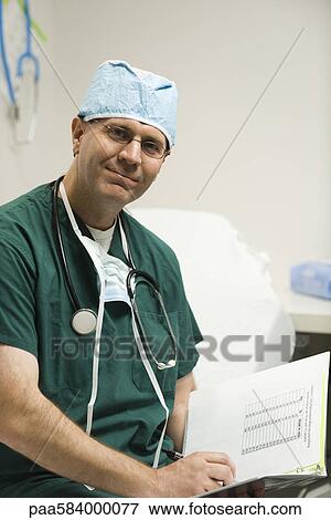 Surgeon reviewing patient's medical chart, portrait View Large Photo Image Stock Photo - Surgeon reviewing patient's medical chart, portrait. Fotosearch