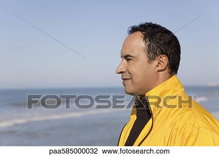 Man looking at the ocean, portrait View Large Photo Image Stock Image - Man looking at the ocean, portrait. Fotosearch