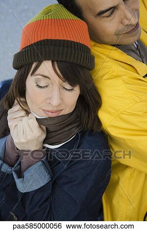 Stock Photograph - Mature couple leaning against each other outdoors. Fotosearch