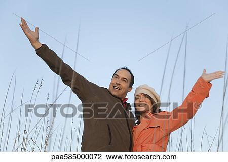 Mature couple outdoors, arms raised, portrait View Large Photo Image Stock Image - Mature couple outdoors, arms raised, portrait. Fotosearch