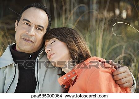Mature couple relaxing together outdoors, portrait View Large Photo Image Picture - Mature couple relaxing together outdoors, portrait. Fotosearch