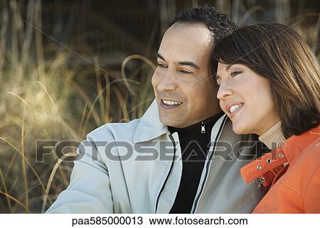 Stock Image - Mature couple relaxing together outdoors, portrait. Fotosearch