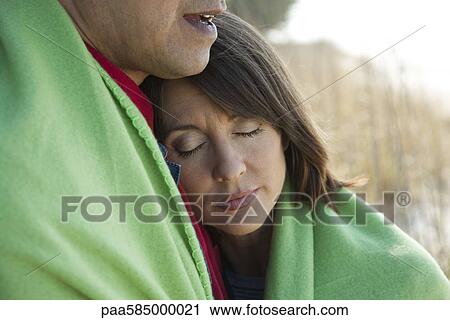 Mature couple sharing blanket outdoors, woman resting head on man's chest View Large Photo Image Stock Image - Mature couple sharing blanket outdoors, woman resting head on man's chest. Fotosearch