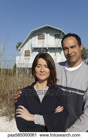 Mature couple standing in front of beach house, portrait View Large Photo Image Stock Image - Mature couple standing in front of beach house, portrait. Fotosearch