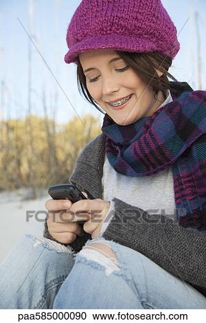 Teen girl text messaging at the beach View Large Photo Image Stock Image - Teen girl text messaging at the beach. Fotosearch