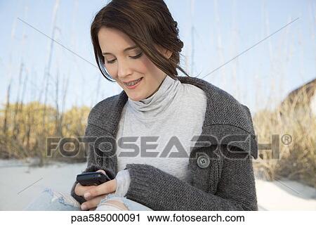 Teen girl text messaging at the beach View Large Photo Image Stock Image - Teen girl text messaging at the beach. Fotosearch