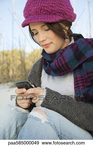 Teen girl text messaging at the beach View Large Photo Image Stock Photo - Teen girl text messaging at the beach. Fotosearch