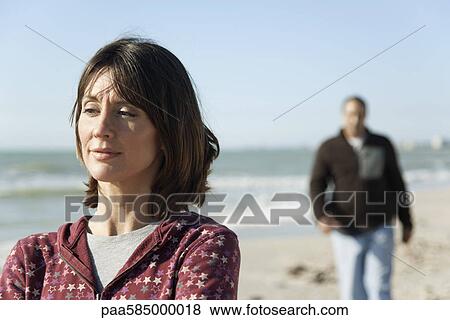 Stock Photo - Woman at the beach, looking away in thought. Fotosearch
