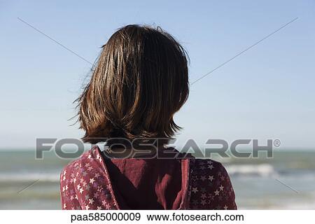 Woman contemplating the ocean, rear view View Large Photo Image Stock Photo - Woman contemplating the ocean, rear view. Fotosearch