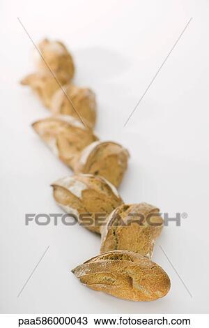 Stock Image - Fresh loaves of bread lined up. Fotosearch