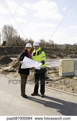 Architect and building contractor discussing blueprint at construction site View Large Photo Image Picture - Architect and building contractor discussing blueprint at construction site. Fotosearch