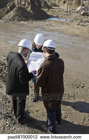 Architect meeting with engineers at construction site discussing blueprints View Large Photo Image Stock Image - Architect meeting with engineers at construction site discussing blueprints. Fotosearch