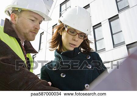 Architects looking at blueprint View Large Photo Image Picture - Architects looking at blueprint. Fotosearch