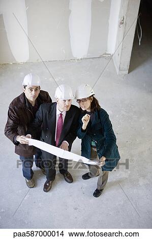 Building contractor and business people discussing blueprint View Large Photo Image Picture - Building contractor and business people discussing blueprint. Fotosearch
