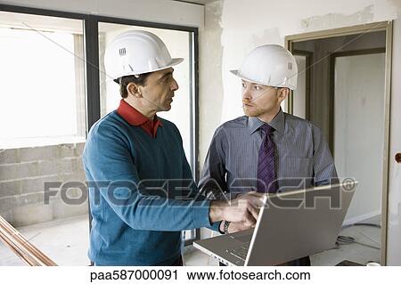 Building contractor and businessman using laptop at construction site View Large Photo Image Stock Image - Building contractor and businessman using laptop at construction site. Fotosearch