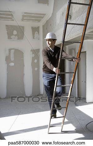 Stock Image - Building contractor climbing ladder. Fotosearch