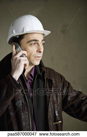 Building contractor using cell phone View Large Photo Image Stock Photo - Building contractor using cell phone. Fotosearch